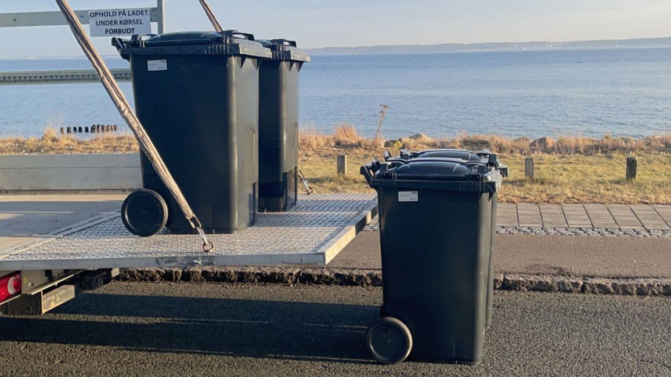 Skraldebil med medarbejder og gadelys